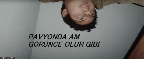 a man 's head is upside down in front of a wall that says pavyonda am gorunca olur gibi