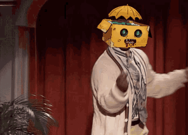 a man wearing a cardboard box on his head with an umbrella on top