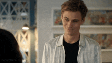a man in a striped shirt is smiling and looking at a woman in a black shirt