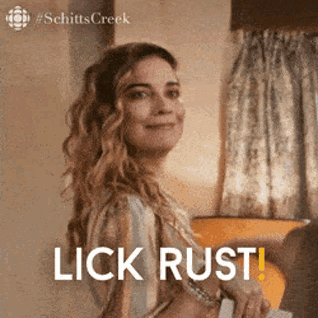 a woman from schitt 's creek is smiling and says lick rust