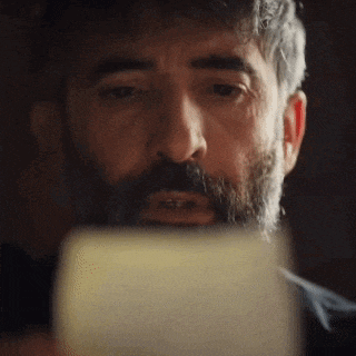 a man with a beard is smoking a cigarette