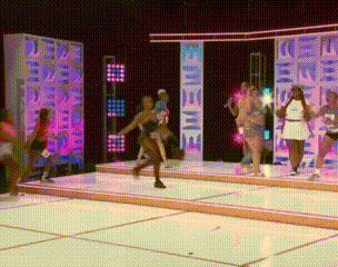 a group of women are dancing on a stage in front of a sign that says ' i love you ' .