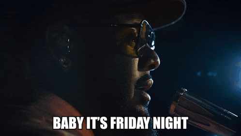 a man singing into a microphone with the words baby it 's friday night