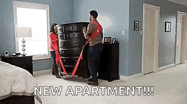 a man and a woman are carrying a dresser in a new apartment .