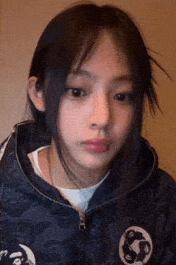a girl wearing a hoodie with a circle with a fish on it