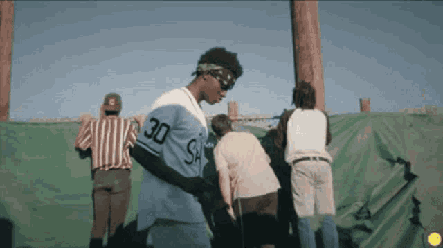 a baseball player wearing a blue jersey with the number 30 on it