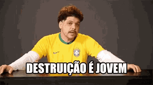 a man in a yellow shirt says " destruicao e jovem " in a foreign language