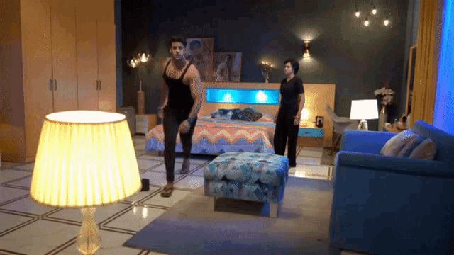 a man in a black tank top is running in a bedroom