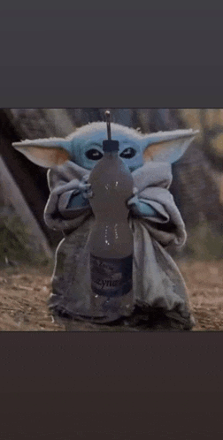 the baby yoda is holding a bottle of water with a straw in his mouth .
