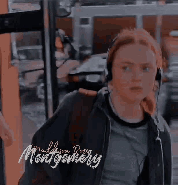 a woman wearing headphones is standing next to a bus .