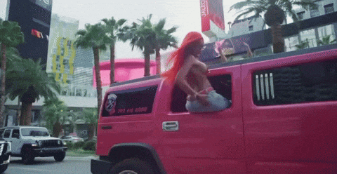 a woman is sitting in a pink limousine with a phone number on the back window