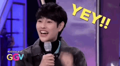 a young man is holding a microphone with the word yey written above him
