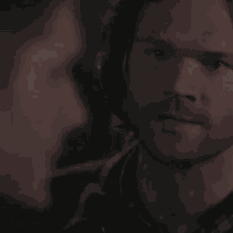 a close up of a person 's face in the dark with smoke coming out of it .
