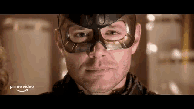 a man wearing a mask is smiling for the camera .