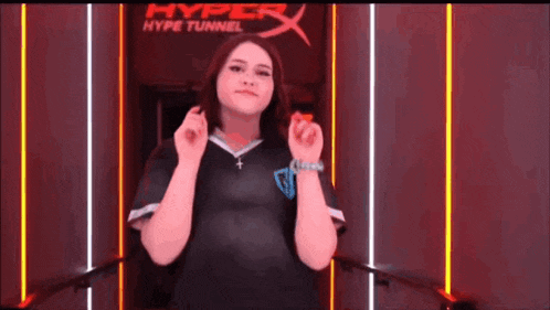 a woman is standing in front of a hyper tunnel sign