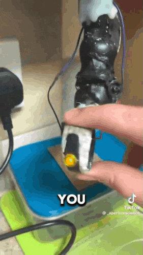 a person is holding a small object that says you on the bottom
