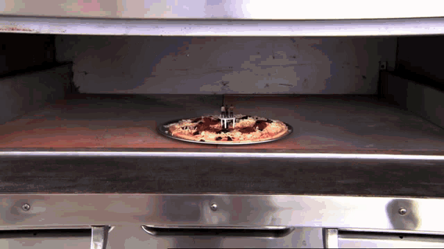 a pizza with a fork sticking out of it is in an oven