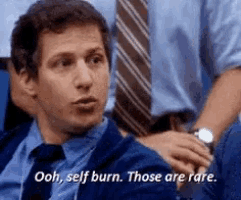 a man in a suit and tie is sitting in a stadium and saying ooh , self burn . those are rare .