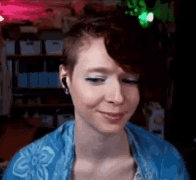 a woman with short hair is wearing headphones and a blue scarf .