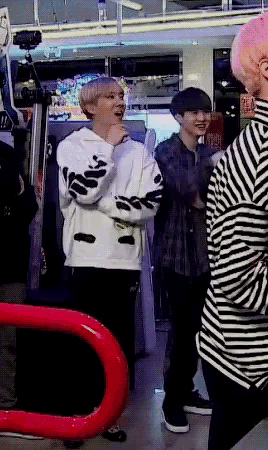 a man wearing a striped shirt is standing next to another man