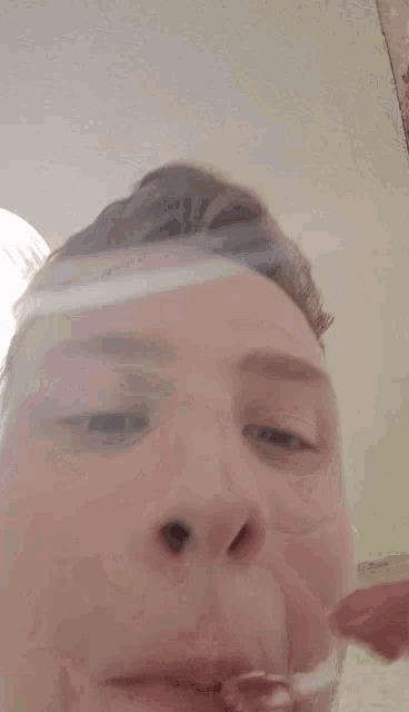 a close up of a person 's face with their eyes closed and a smile on their face .