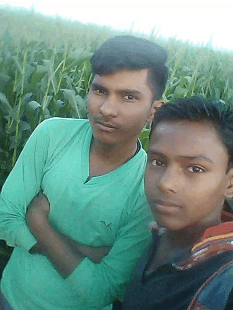 a man in a green puma shirt poses with another man