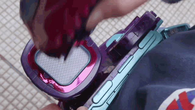 a person is holding a purple and blue item with the letter o on it