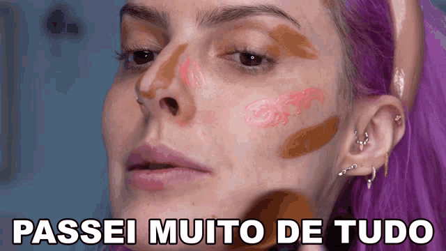 a woman with purple hair has makeup on her face and the words passei muito de tudo are below her