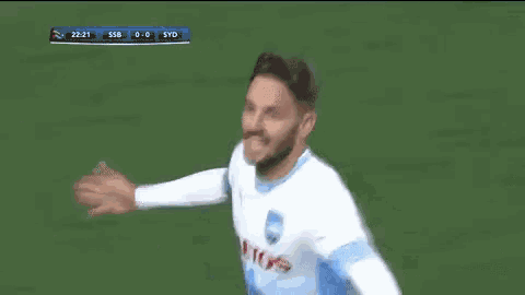 a soccer player wearing a jersey that says " aetos " is celebrating a goal