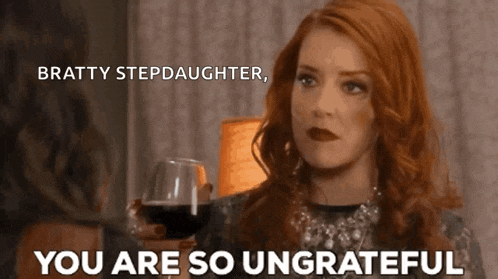 a woman with red hair is holding a glass of wine and says " bratty stepdaughter "
