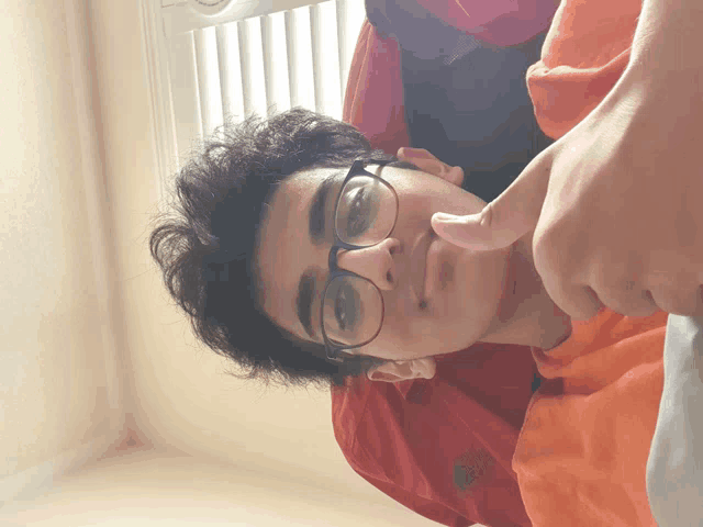 a young man wearing glasses and an orange shirt with the word nike on it