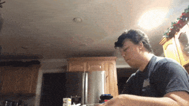 a man standing in a kitchen with a container of kraft singles