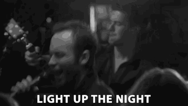 a black and white photo of a crowd with the words light up the night below it