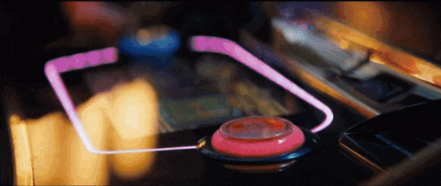 a close up of a pink button with a glowing line going through it