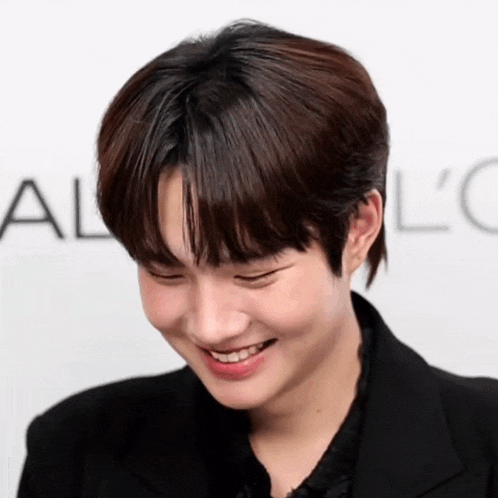 a young man is smiling in front of a sign that says al