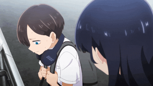 a boy with a backpack and a scarf around his neck looks down