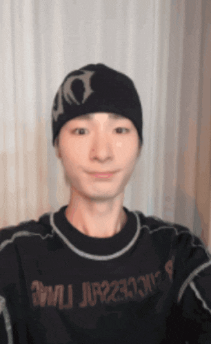 a man wearing a beanie and a shirt that says 3mjjp233n7