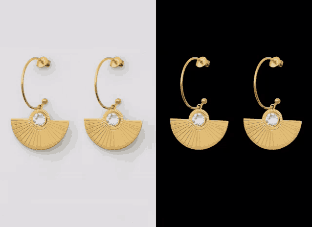 a pair of gold hoop earrings with a fan shaped pendant