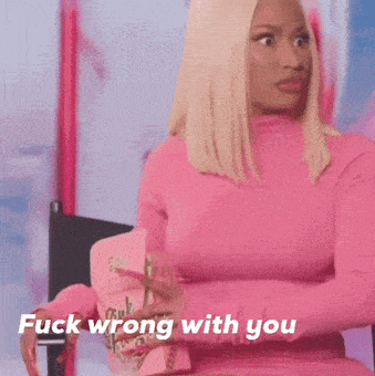a woman in a pink top is sitting in a chair and says fuck wrong with you