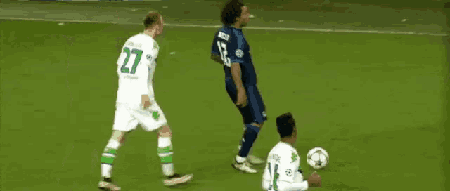 a soccer player wearing a fly emirates shirt holds a soccer ball