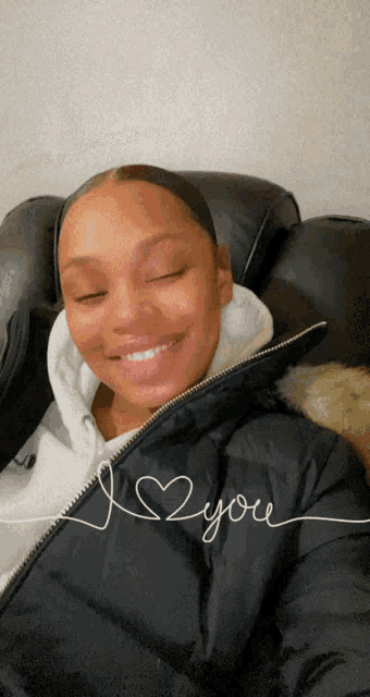 a woman wearing a black jacket with the words i love you on it