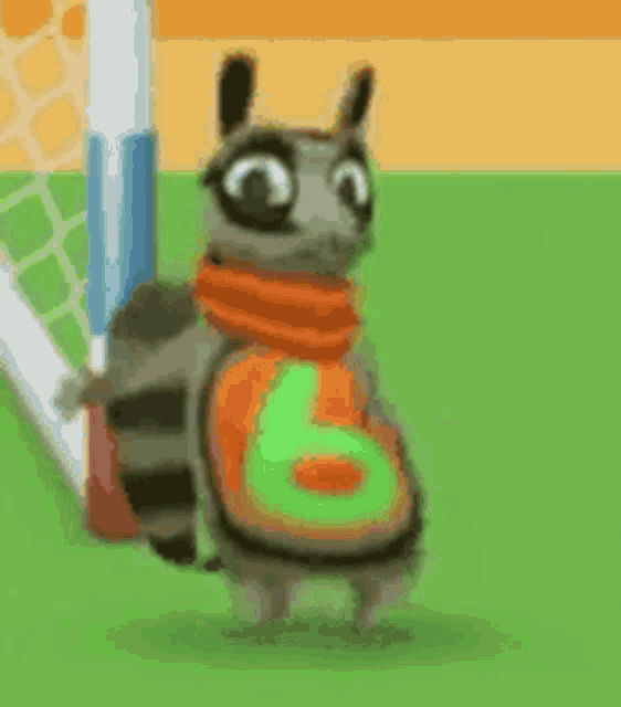 a raccoon wearing a scarf and a number six shirt is standing on a field .