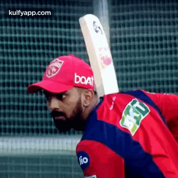 a man is holding a cricket bat on his back .