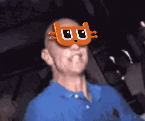 a man in a blue shirt is wearing a pair of orange glasses with the letter u on them