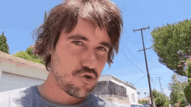 a man with a beard looks at the camera