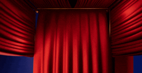 a blurred image of a person 's hands holding a red curtain behind them