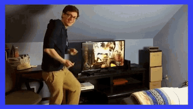 a man is dancing in front of a television with a video game on it