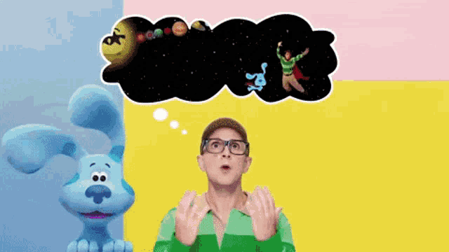 a man wearing glasses and a green shirt stands in front of a blue dog