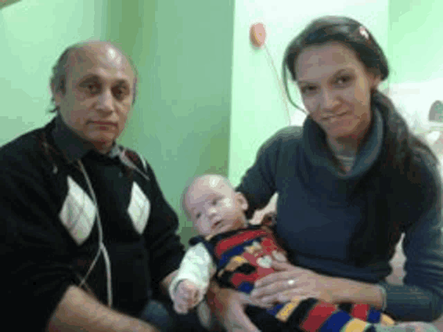 a man and a woman are holding a baby in their arms
