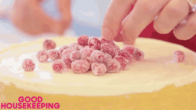 a cake with raspberries on top of it and the words good housekeeping in the corner